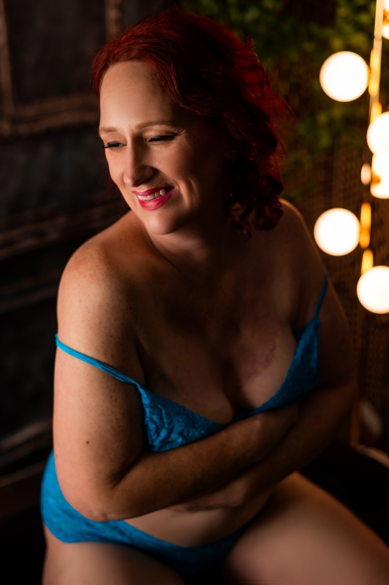 A in blue lingerie laughs at a boudoir studio in rochester new york.